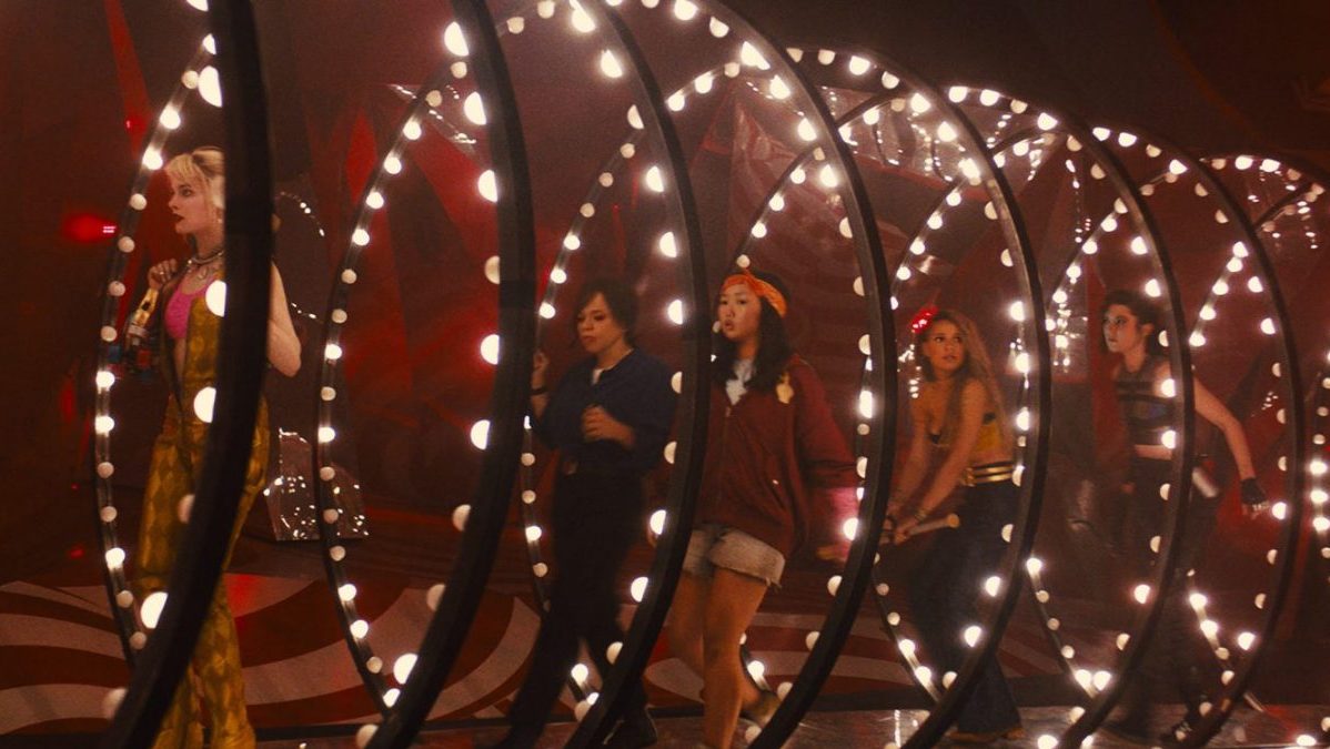 Harley Quinn leads the Birds of Prey down a glowing tube.