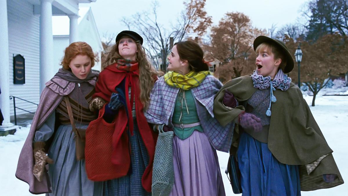 The March sisters walk together in the snow, happily.