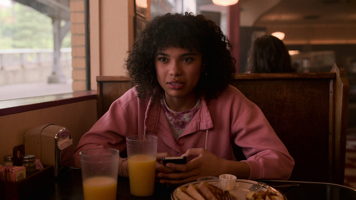 Dina sits in a diner booth.