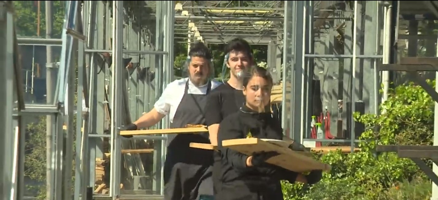 wait staff brings food to customers on wooden slab