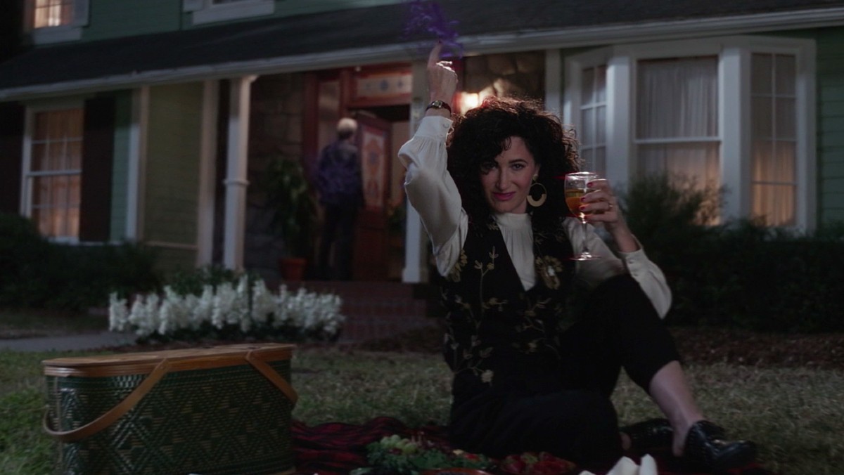 Kathryn Hahn's Agatha Harkness performs magic and holds a glass of wine in a scene from WandaVision.