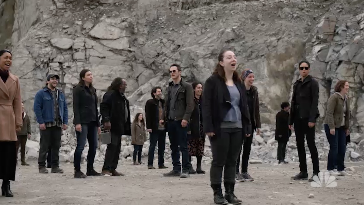 A large group of people stand outside in a rock quarry