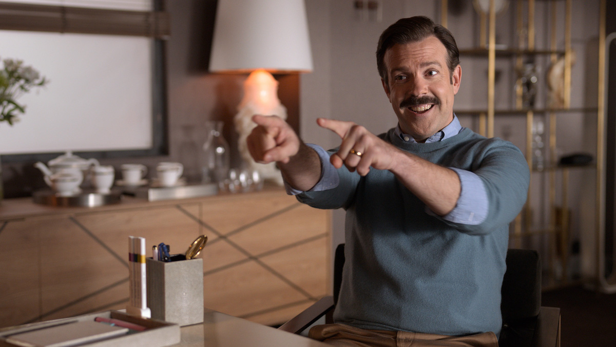 Ted Lasso (Jason Sudeikis) points while looking excited.