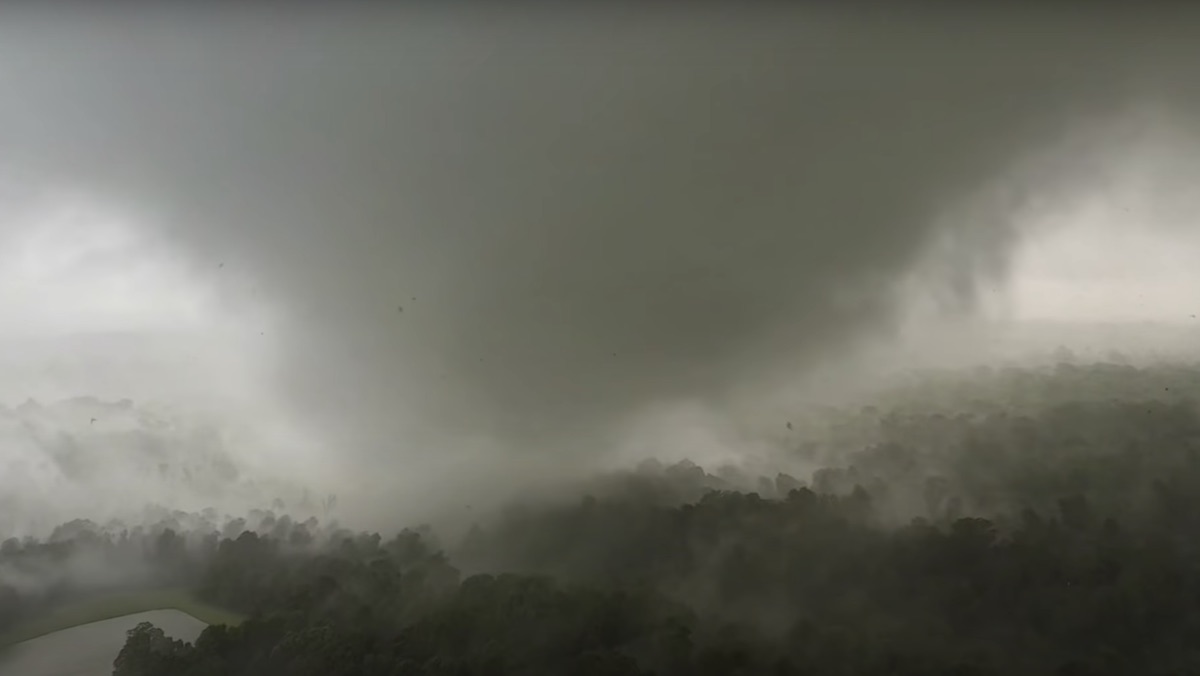 A tornado sweeps across a gray-tinted forest in Missouri