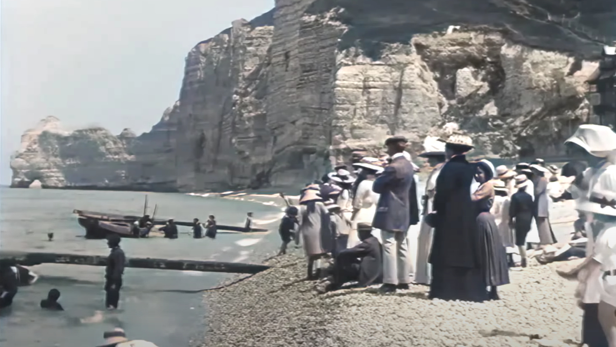 A group of Parisians stand on the beach in 1899.