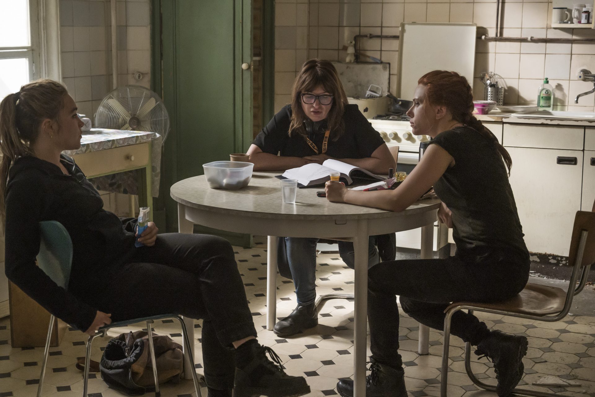 Scarlett Johanson, Florence Pugh, Cate Shortland in Black Widow sit around a table in a behind the scenes image