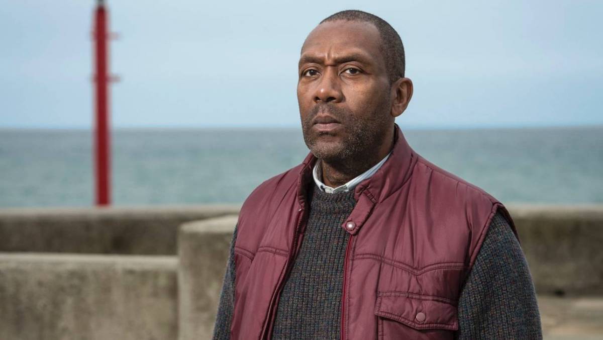 A man in a vest looks serious