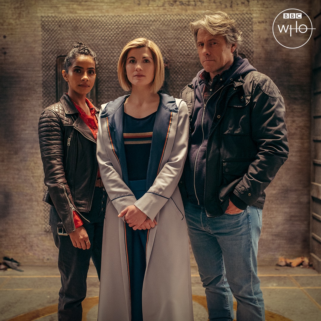 Yaz (Mandip Gill) wears a leather jacket, the Doctor (Jodie Whittaker) wears her usual costume, and Dan (John Bishop) wears a jacket and jeans, in a promo image for the new series of Doctor Who.