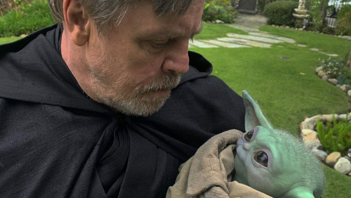 Mark Hamill holding the Grogu/Baby Yoda puppet in The Mandalorian