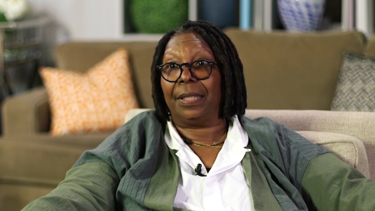 photo of Whoopi Goldberg in an interview wearing a green jacket and white shirt