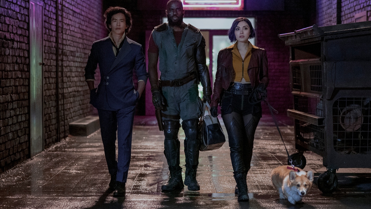 photo of John Cho, Mustafa Shakir, and Danielle Pineda walking down street with corgi in Cowboy Bebop