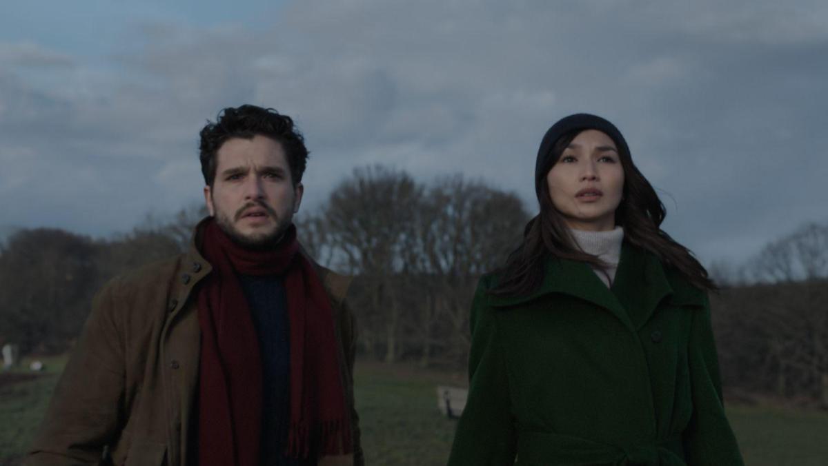 A still from Eternals shows Kit Harrington as Dane Whitman and Gemma Chan as Sersi standing in a park in London