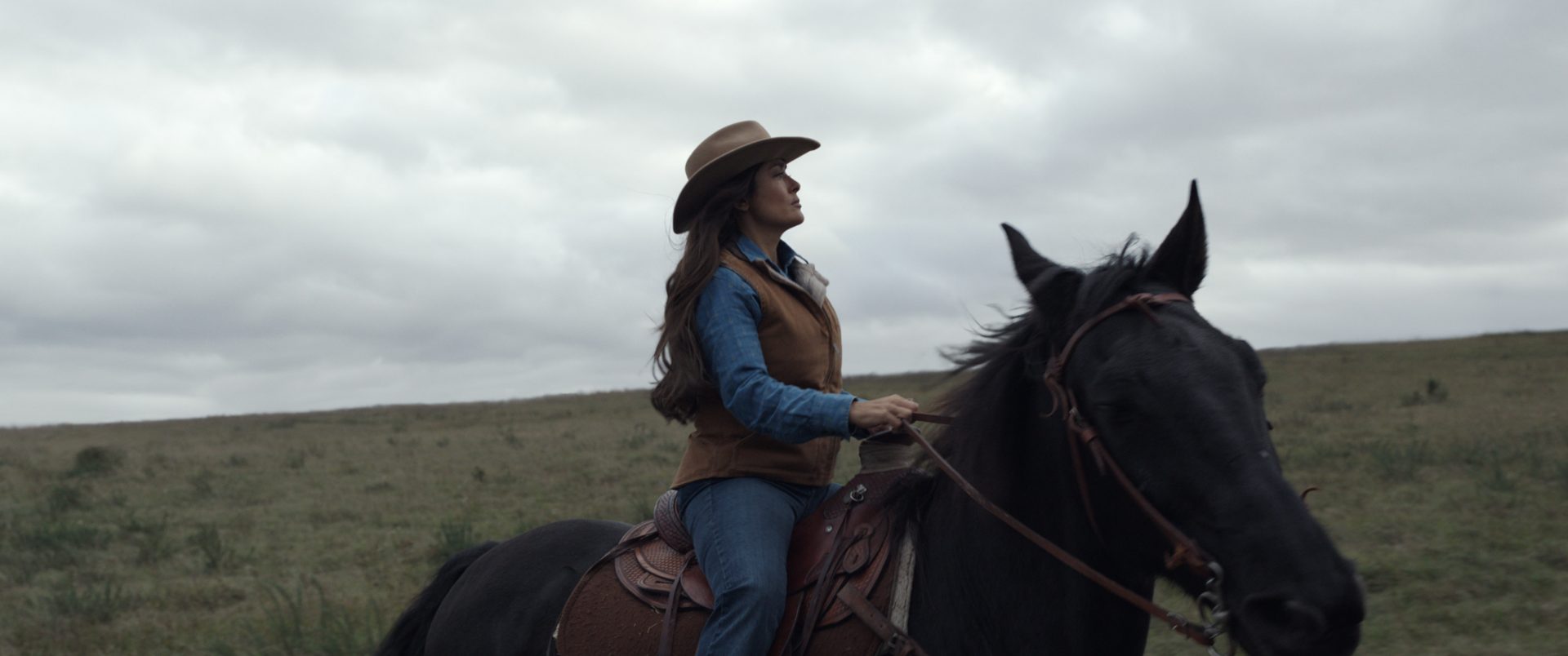 A still from Eternals shows Selma Hayek as Ajak riding a horse in South Dakota