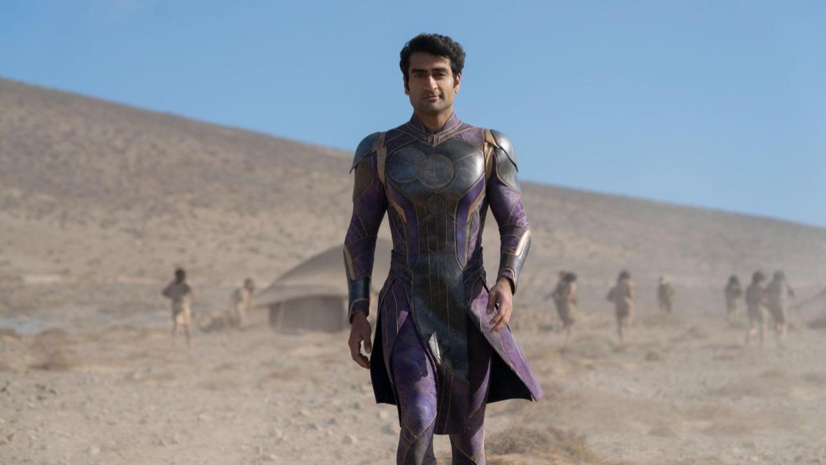 A still from Eternals shows Kumail Nanjiani as Kingo striding towards the camera