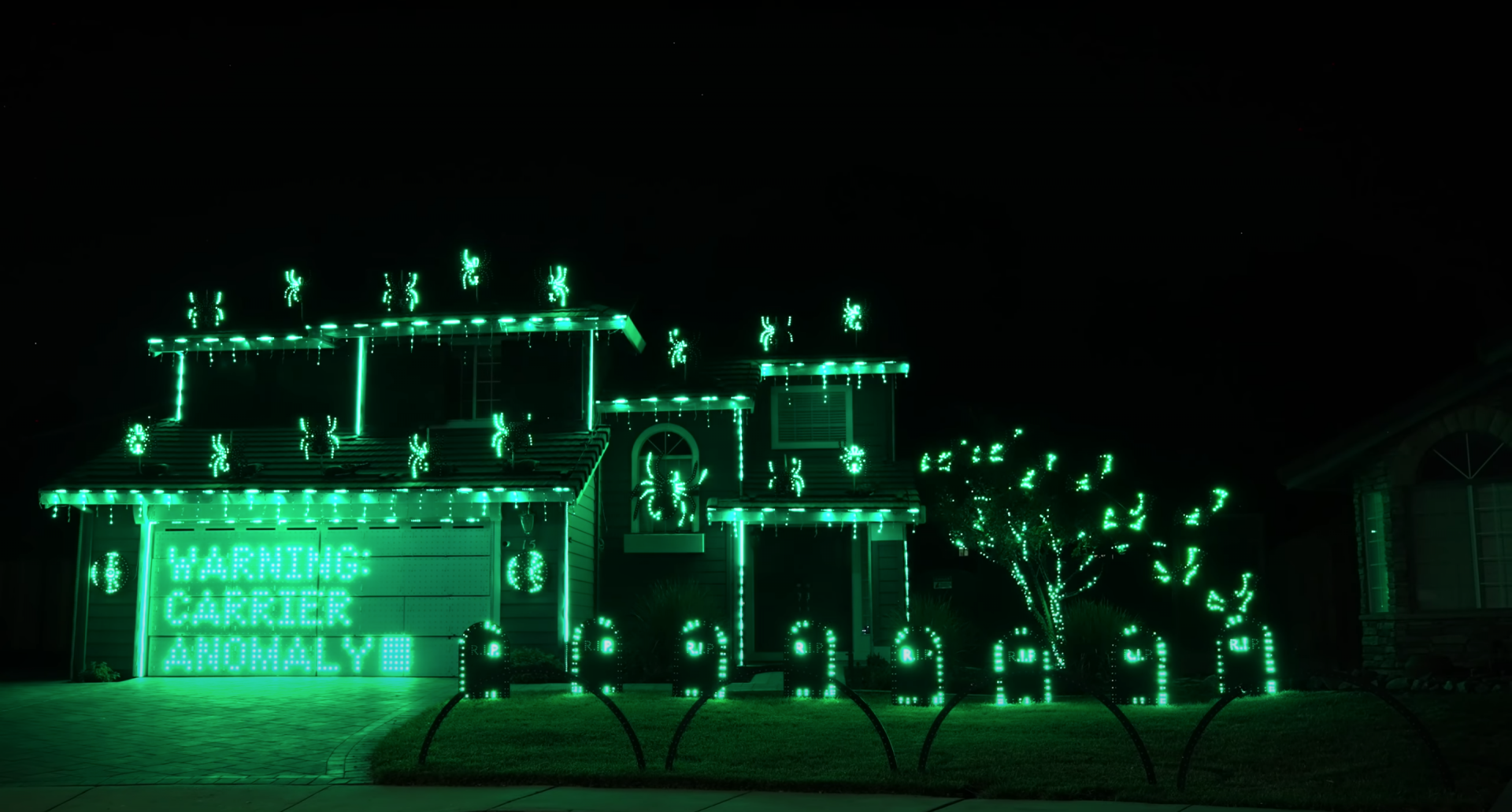 A house lit up with Halloween lights that flash in sync with the audio and music from the final scene of The Matrix.