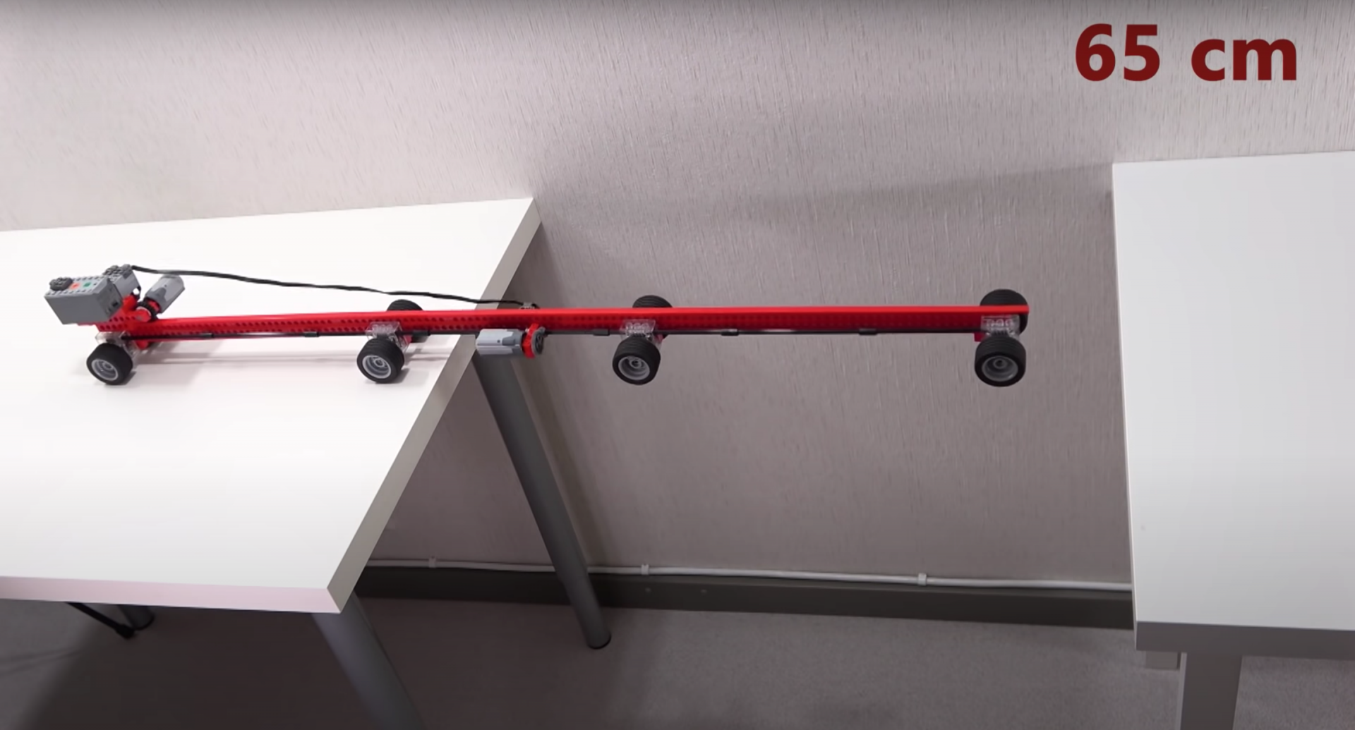 An adaptable RC LEGO car attempting to bridge a 75 centimeter gap between two tables.