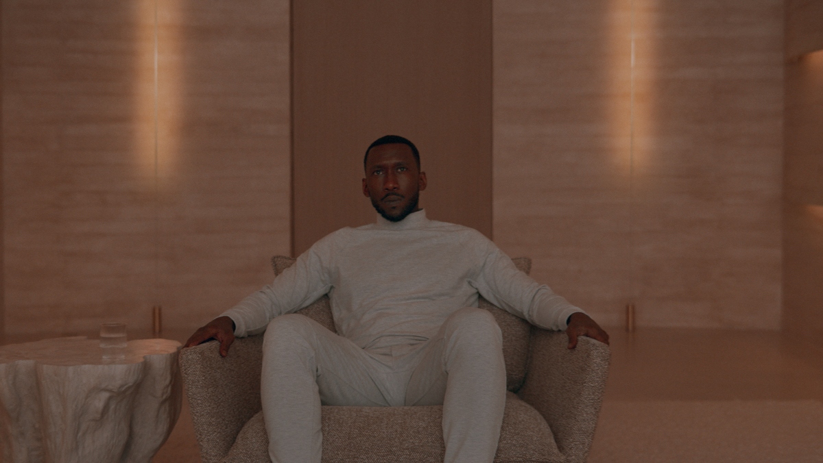 Mahershala Ali sits on a couch in swan song trailer clip