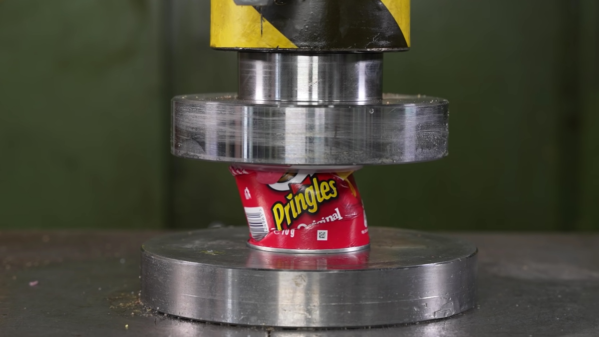 A hydraulic press crushing down on a can of Pringles, in between crushing many other household items in a satisfying way.