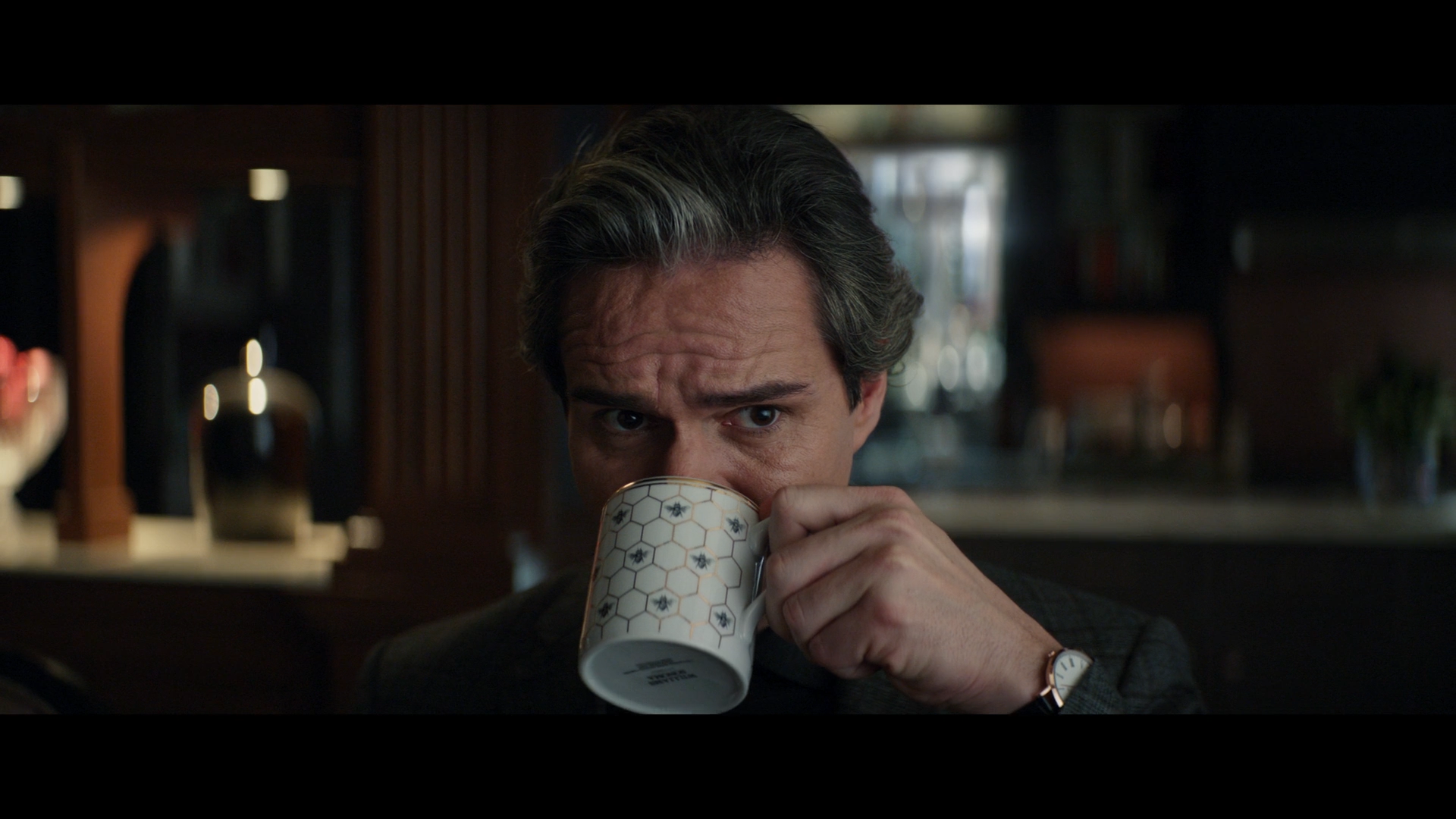 A still from Hawkeye shows Tony Dalton as Jack drinking out of a cup covered with Hexagons