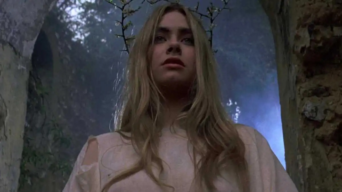 Linda Hayden wears a crown of sticks and stands in a ruined, overgrown cathedral in the 1971 folk horror film The Blood on Satan's Claw.