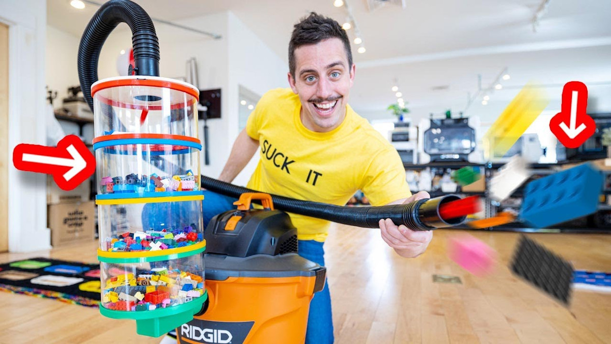 Matty Benedetto holding a vacuum cleaner full of sorted LEGO pieces