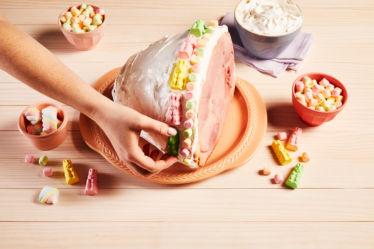 A hand places candy during the making of a Reynolds Wrap Marshmallow Easter Ham