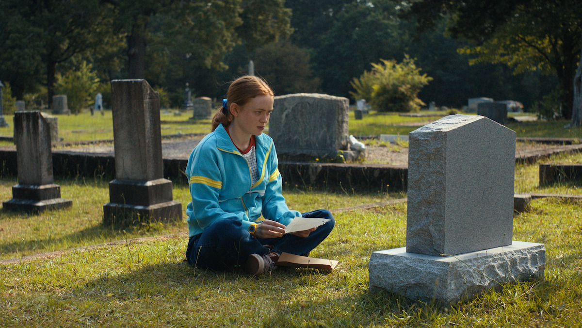 Sadie Sink as Max Mayfield sits at Billy's grave in Stranger Things 4