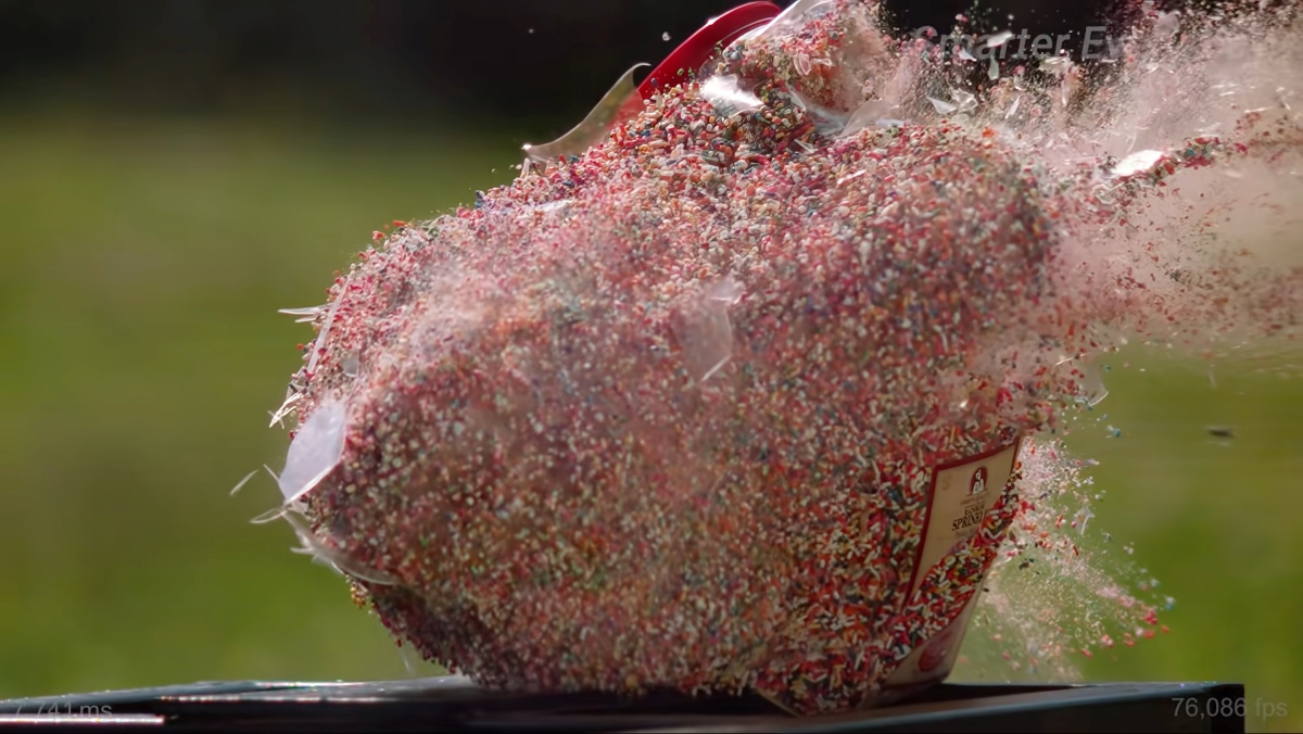 A plastic container of sprinkles mid-explosion