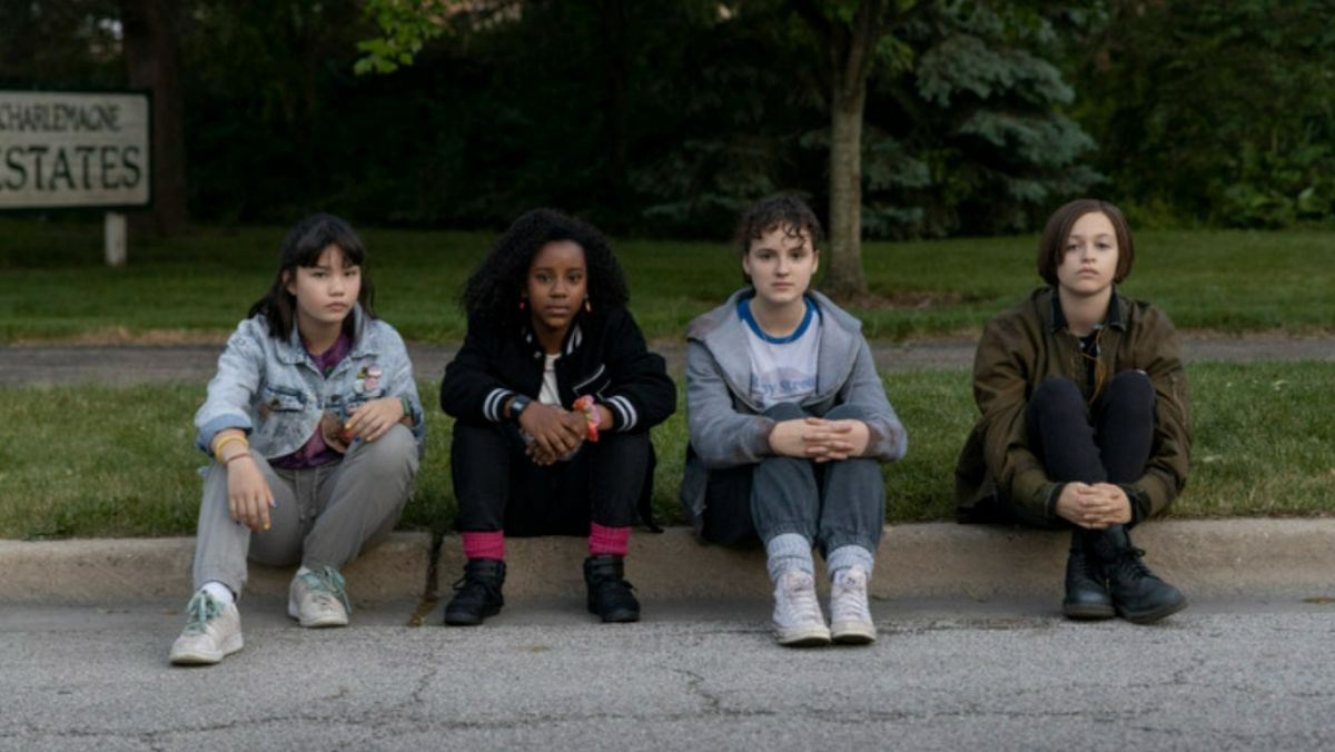 photo of four girls sitting on a curb in paper girls tv show 