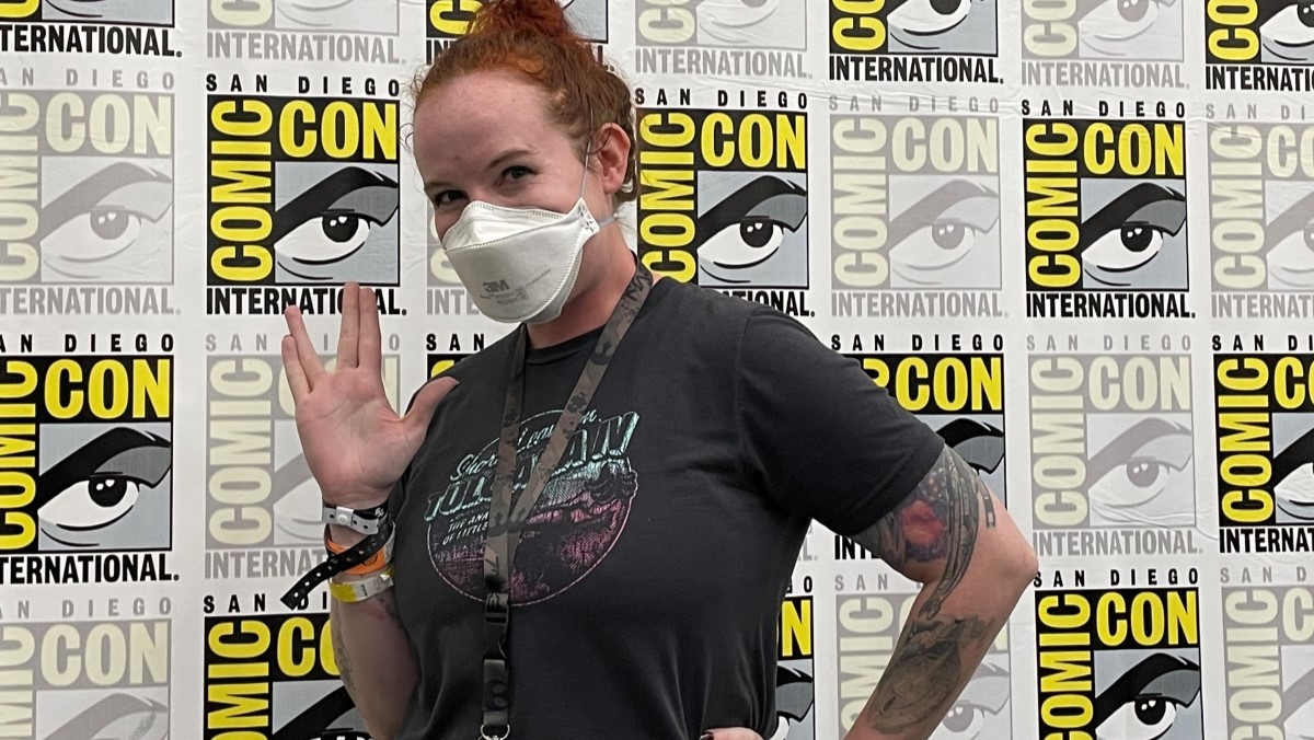 Erin Macdonald flashes the "Live long and prosper" hand signal in front of the San Diego Comic-Con backdrop