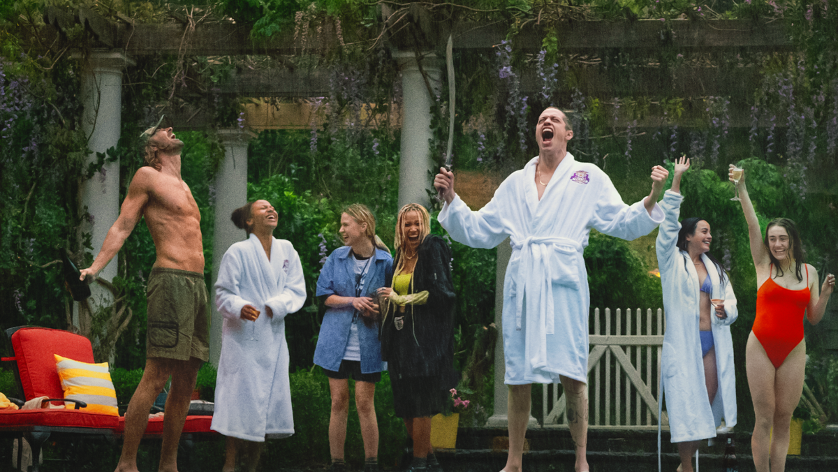 photo of a group of young adults screaming in the rain and wearing bathing suits and robes bodies bodies bodies movie