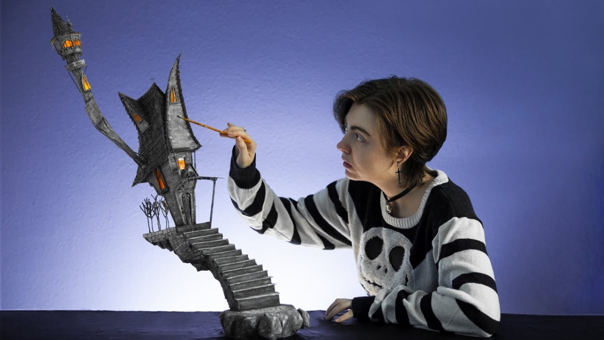 A maker paints a model of Jack Skellington's house from The Nightmare Before Christmas