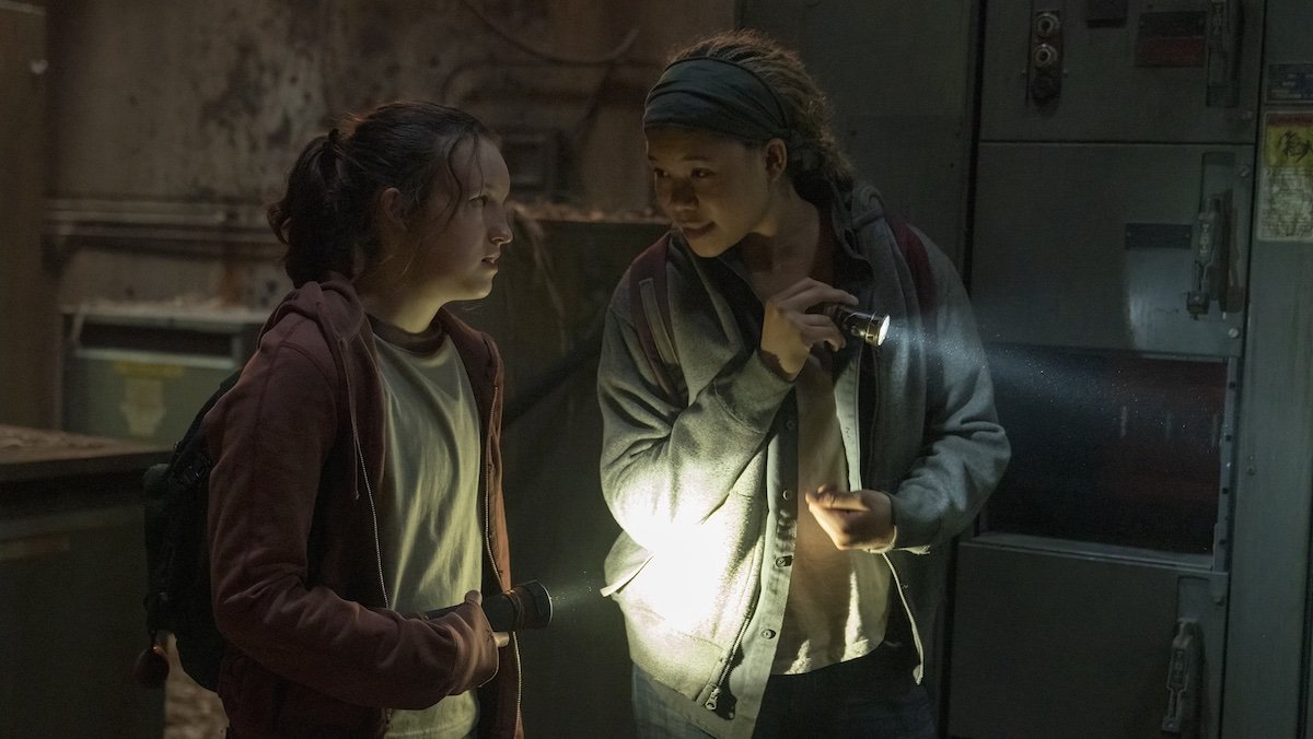 Ellie and Riley hold their flashlights while talking on The Last of Us