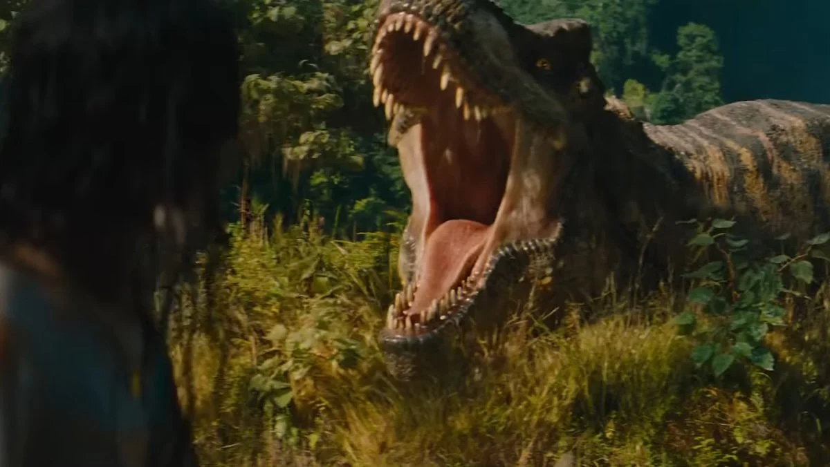 A T.Rex roars with a woman facing it in the foreground in Jurassic World Rebirth for Dinosaur sex scene article