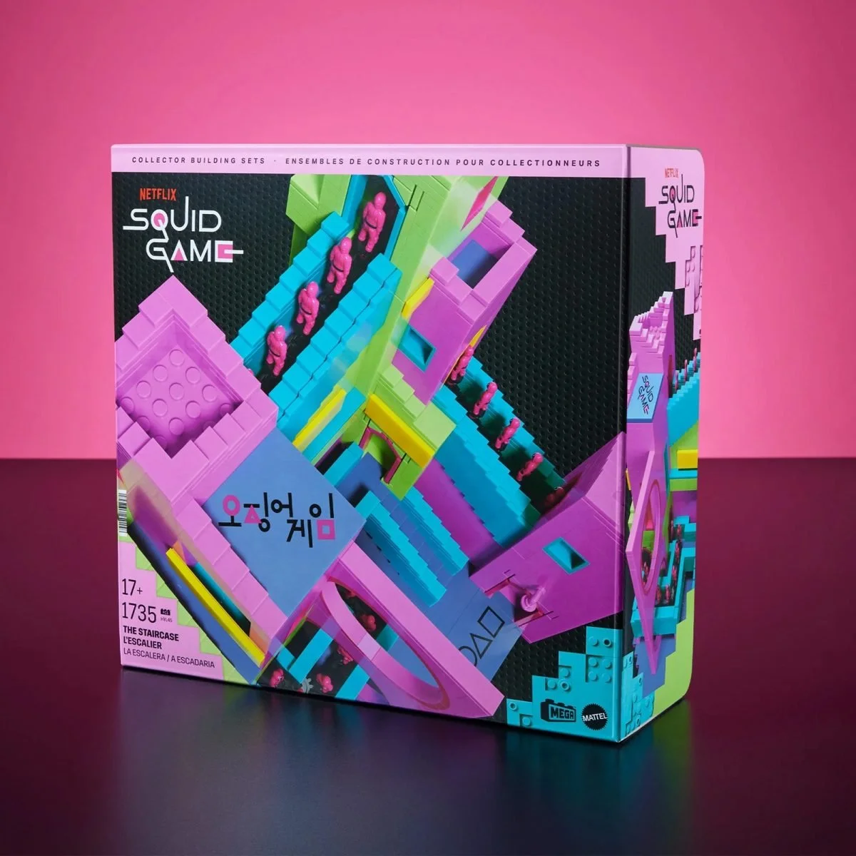A colorful Squid Game-themed building set box features vibrant staircases in pink, green, blue, and yellow, with miniature figures. Branding includes Netflix, Mega, and “The Staircase” with 1,735 pieces.