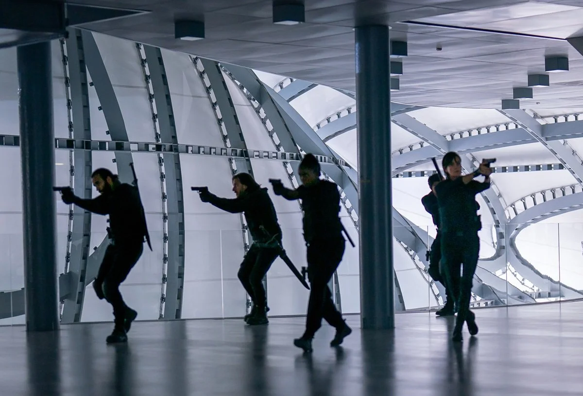 The immortal mercenaries of The Old Guard 2 draw their guns against an enemy. 