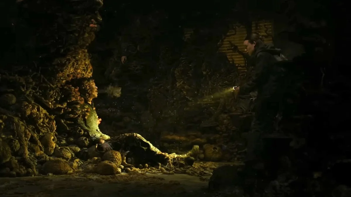 Ellie sees an infected stuck to the wall breathing out spores on The Last of Us