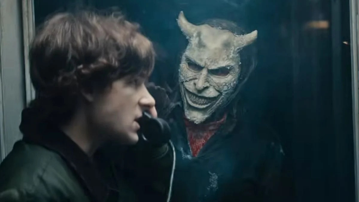 image from the black phone 2 sequel trailer of the grabber looking at finn inside a phone booth