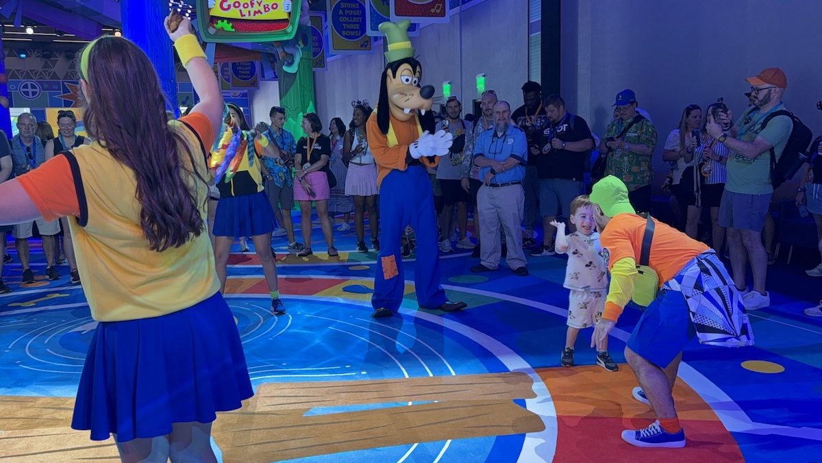 A little kid high-fiving a Goof Troop member while Goofy looks on.