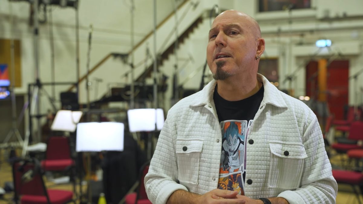 A bald man with a think goatee in a white shirt