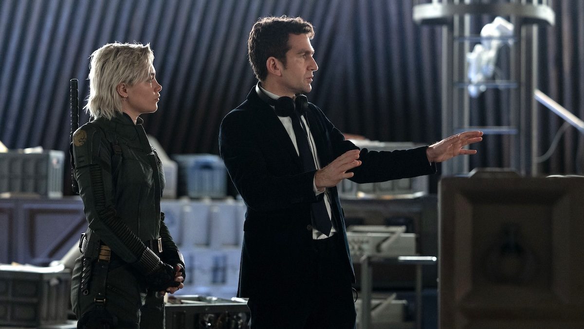 Florence Pugh stands behind director Jake Schreier who is pointing while shooting Thunderbolts*