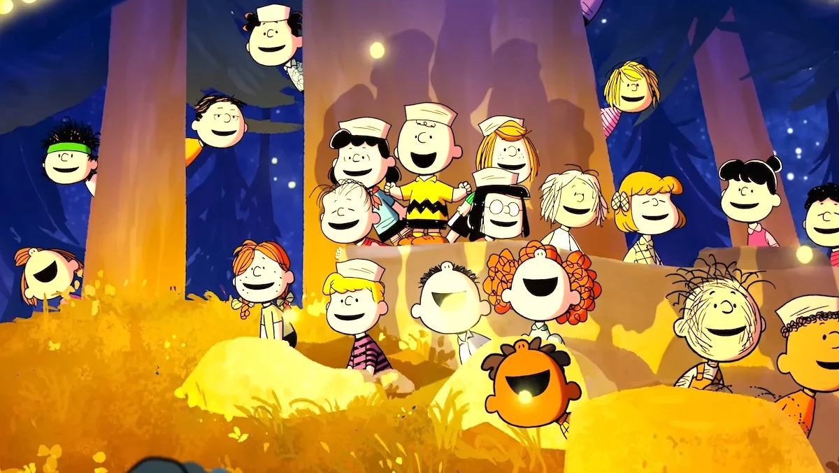 Charlie Brown and Peanuts kids singing near a tree and fire in Snoopy Presents: A Summer Musical