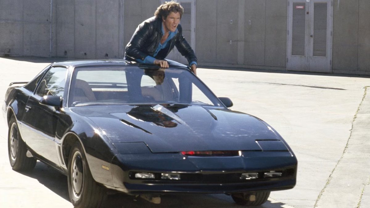 Michael Knight (David Hasselhoff) stands up through the sunroof of KITT in Knight Rider.