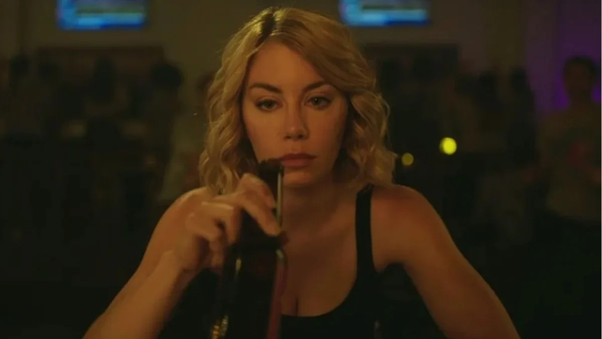 Agent Harcourt (Jennifer Holland) in Peacemaker drinks away her problems.