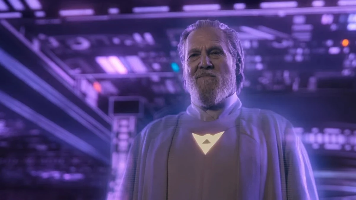 A bearded Jeff Bridges in a white robe bathed by purple light in Tron: Ares