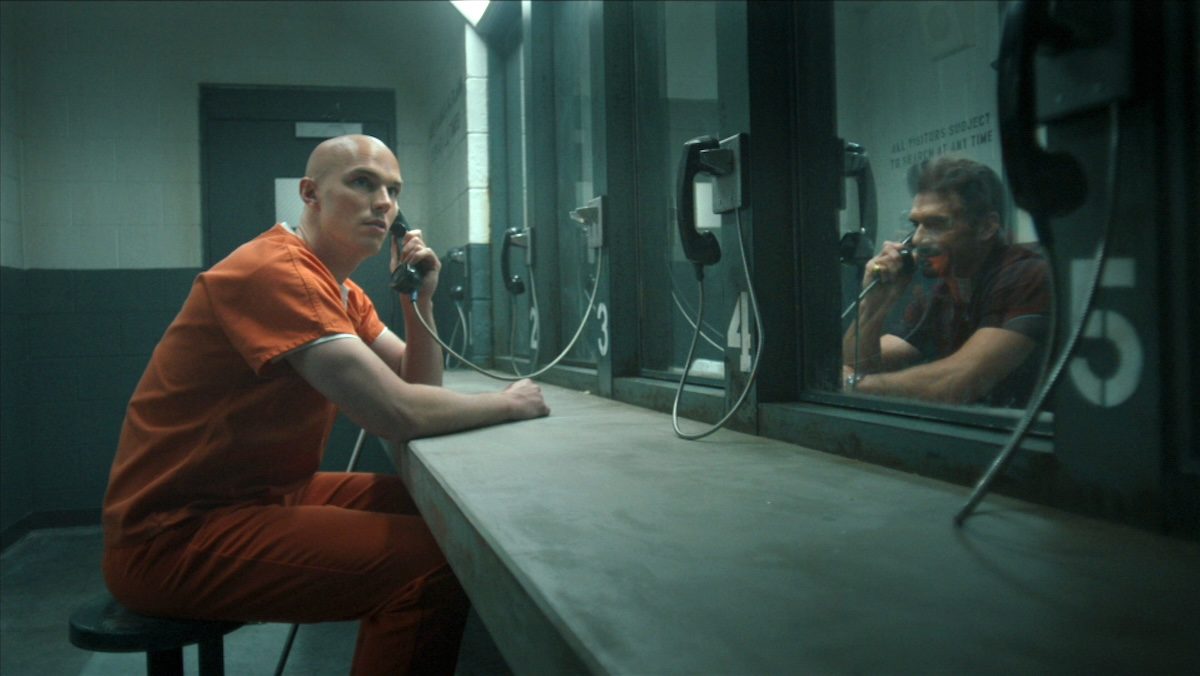 Nicholas Hoult as Lex Luthor talking on a prison phone to Rick Flagg Sr on Peacemaker