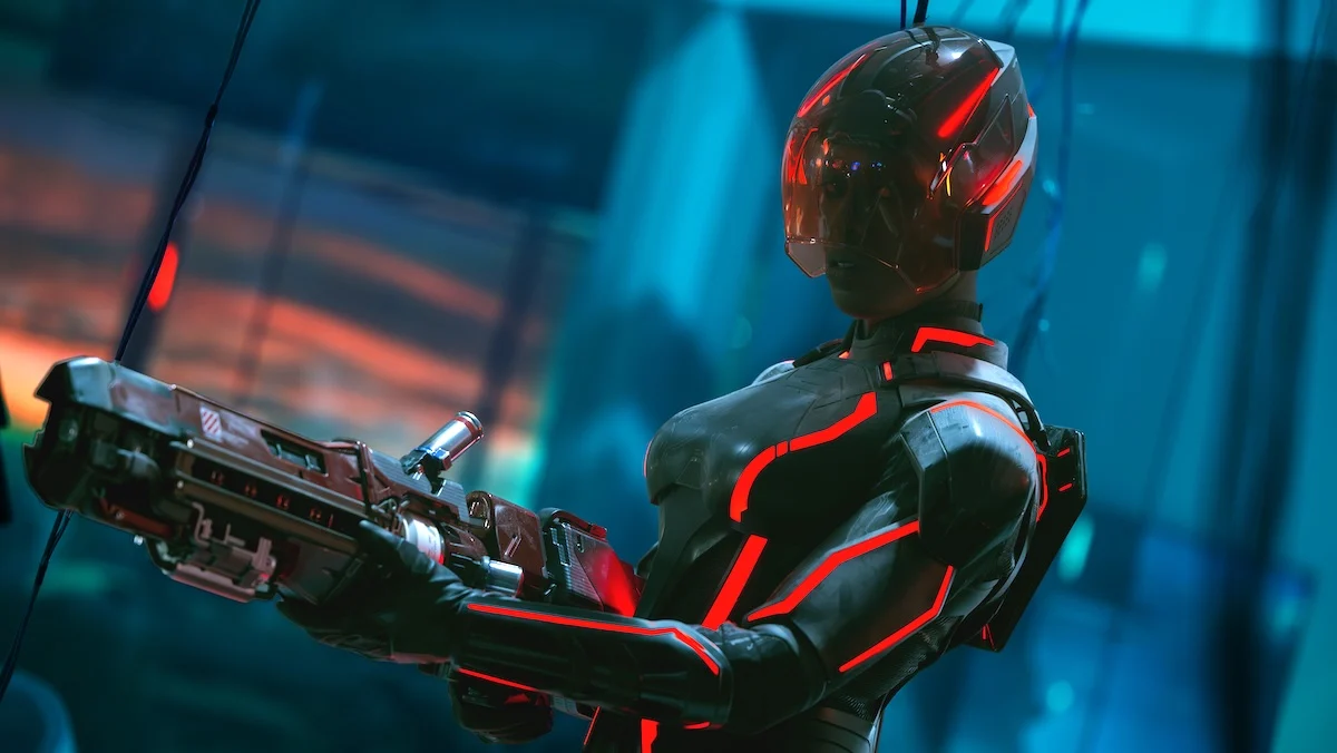 A masked Jodie Turner-Smith in her black and red grid suit holding a particle gun in Tron: Ares